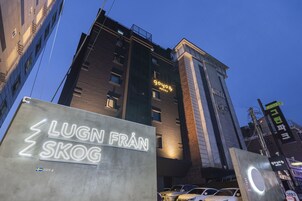 Un hotel con un letrero de neón que dice "goyos" y otro letrero para "Lugn Från Skog".