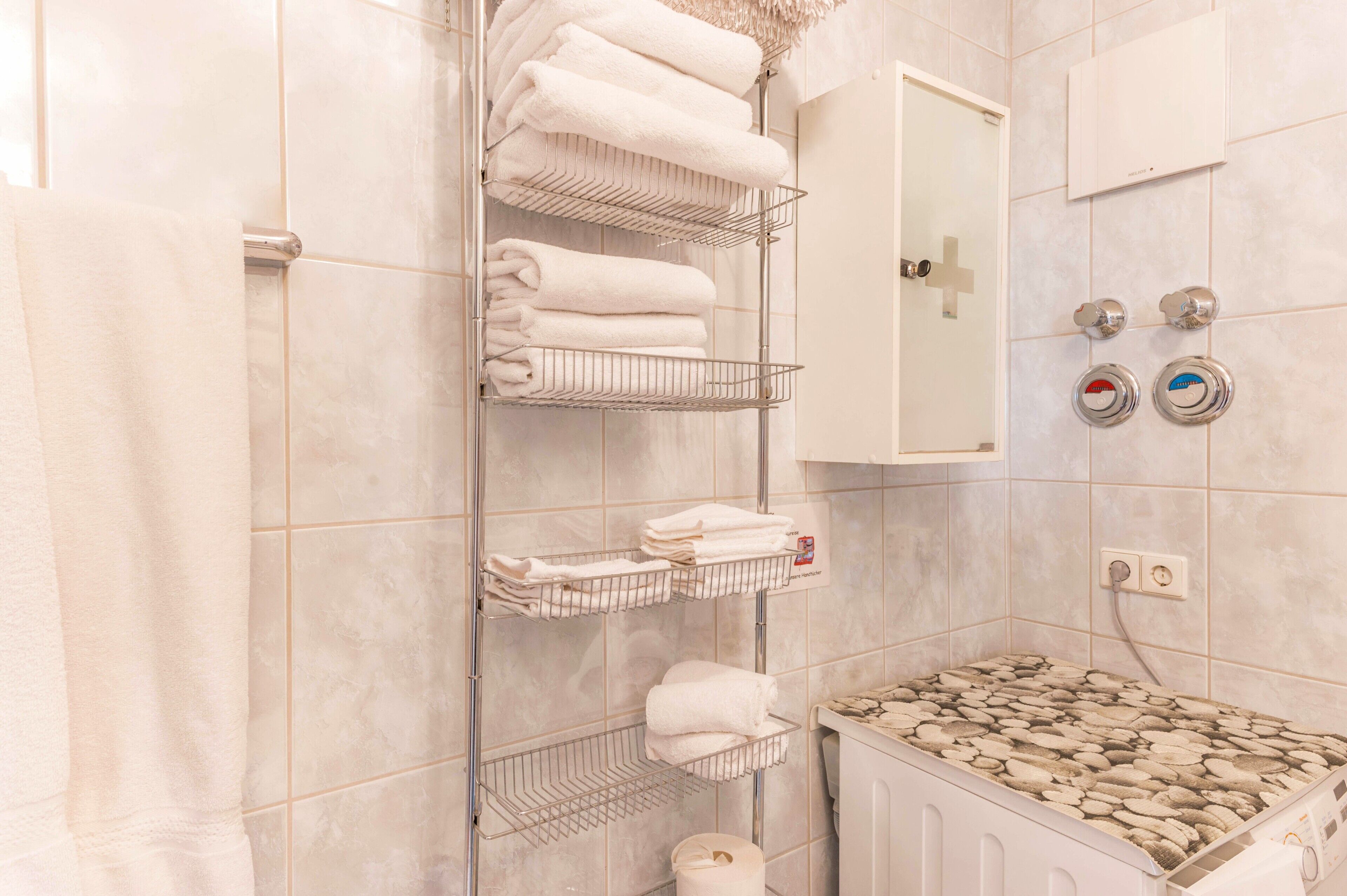 Ein Badezimmer mit Dusche, Handtuchhalter, Toilette und Waschbecken.
