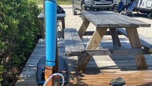 A wooden deck with a hose and a small statue. - Incommunicado Gulf Front Private RV Lot (Port St. Joe)