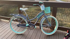 A bicycle with a basket and a name tag on a wooden deck overlooking a marshy landscape. - Incommunicado Gulf Front Private RV Lot (Port St. Joe)
