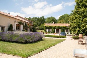 Eine Villa mit Garten, Kiesweg und Gartenmöbeln.