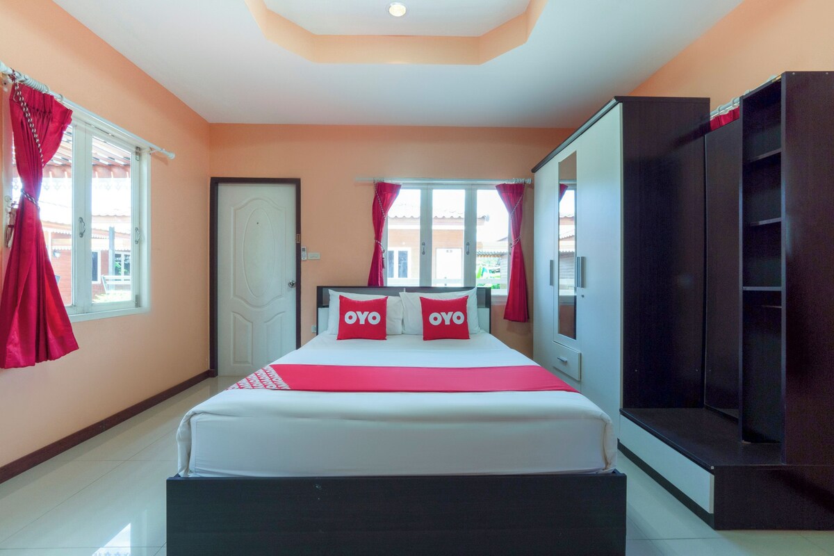 Un dormitorio con cama, armario, televisor y puerta.