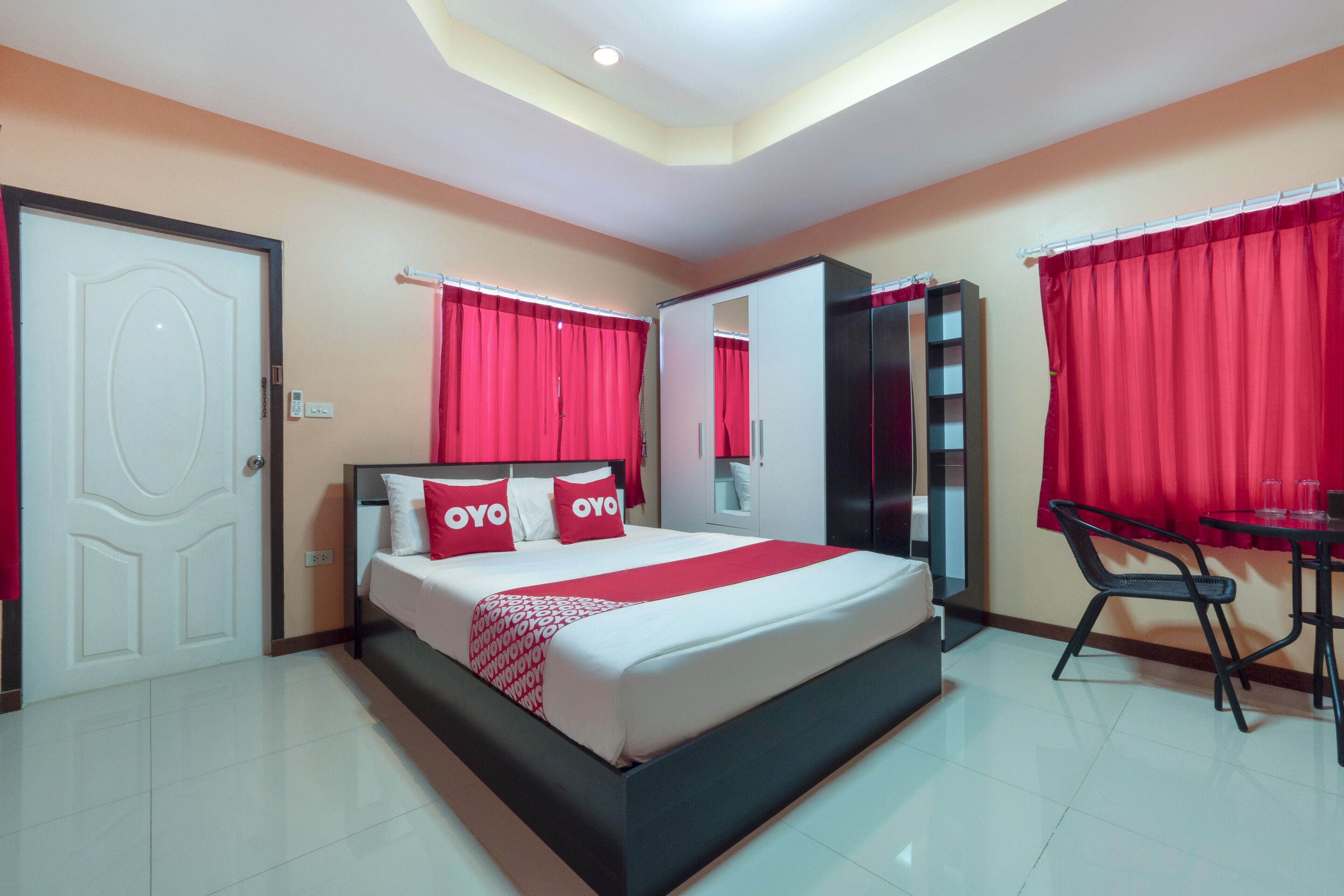 Una habitación de hotel con cama, escritorio, silla, armario y puerta.