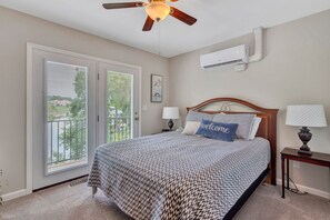 A bedroom with a bed, a nightstand, a ceiling fan, a window with blinds, and an air conditioning unit. - Break Away - sleeps 12, kayaks, SUP's fire pit, games galore! Great for kids and adults! (Moneta)