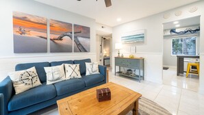 A living room with a blue sofa, a wooden coffee table, and a ceiling fan.