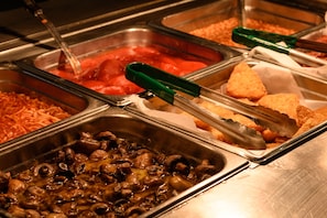 A buffet with various food options including pasta, mushrooms, and bread. - Oasis at Newman (Newman)