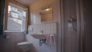 Un baño con inodoro, lavamanos y ducha.