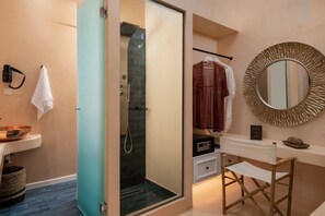 Ein Badezimmer mit Dusche, Waschbecken, Spiegel und Handtuchhalter.