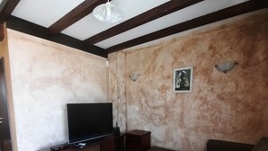 A living room with a TV, sofa, and coffee table. - Beautiful 2-bed Villa in Cholakova Cheshma (Kosharitsa)