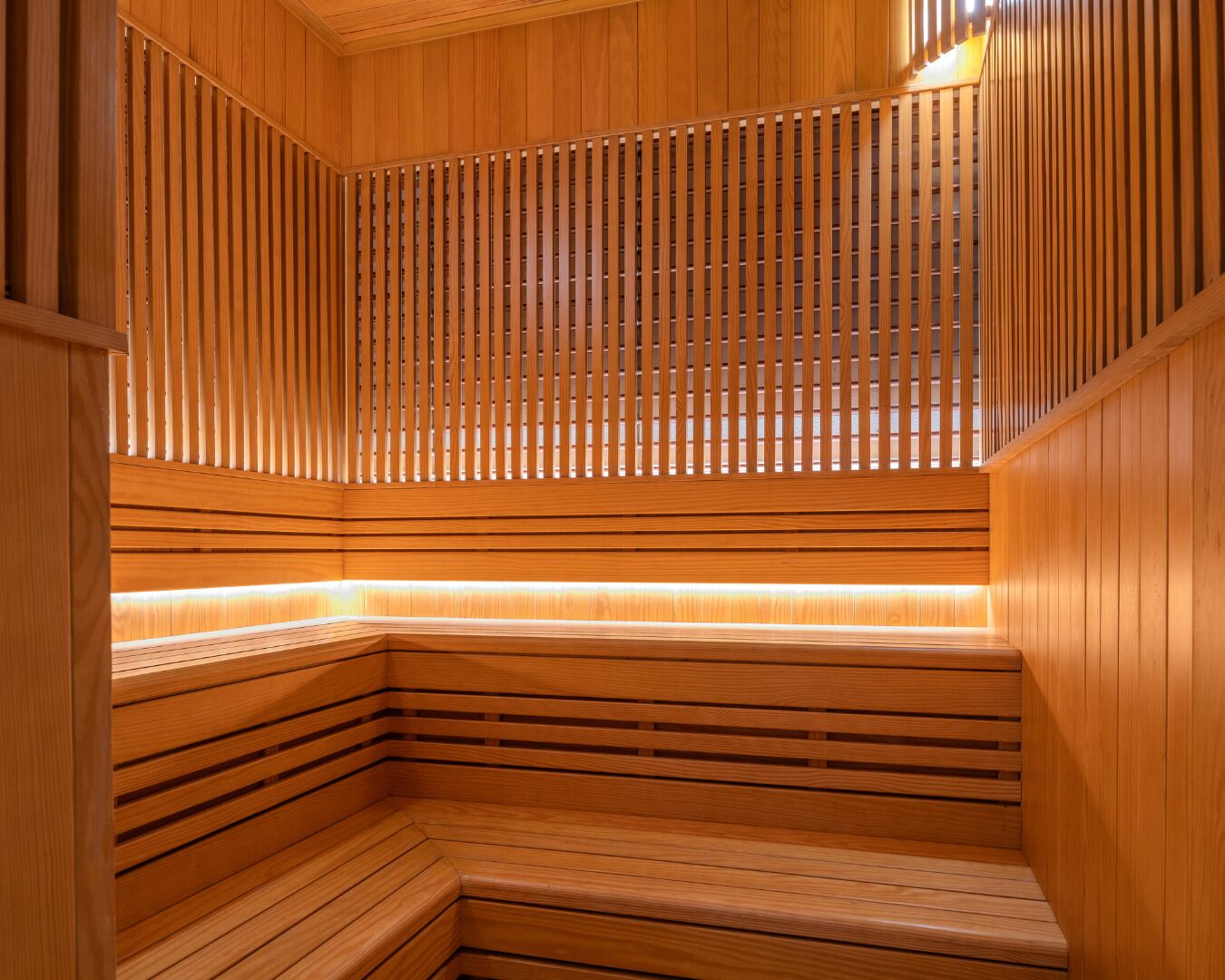 A wooden sauna with slatted walls and benches.