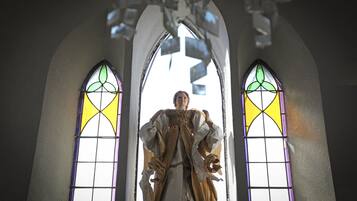 A statue in a church with stained glass windows.