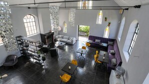 A spacious interior with a high ceiling, modern furniture, and large windows allowing natural light. - Valerius Boutique Hotel (Wormer)
