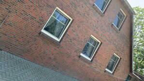A corner brick building with two windows and a visible roof edge. - Haus Landruhe, Deutschland (Neuharlingersiel)