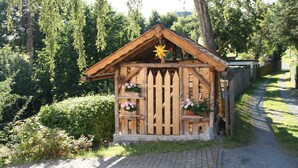 Une cabane en bois ornée d’une étoile sur le toit, entourée de verdure.