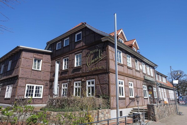 A multi-story hotel with a traditional brick facade, large windows, and a prominent sign reading 'Hotel Gyenik.'