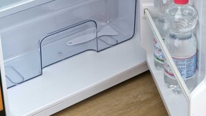 Un refrigerador abierto con contenedores de plástico transparentes y botellas.