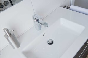 Un lavabo de salle de bain avec un robinet chromé et un distributeur de savon.