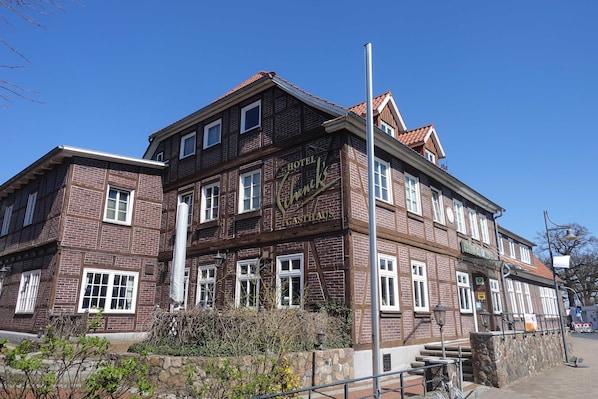 A multi-story hotel with a traditional brick facade, multiple windows, and a prominent sign.
