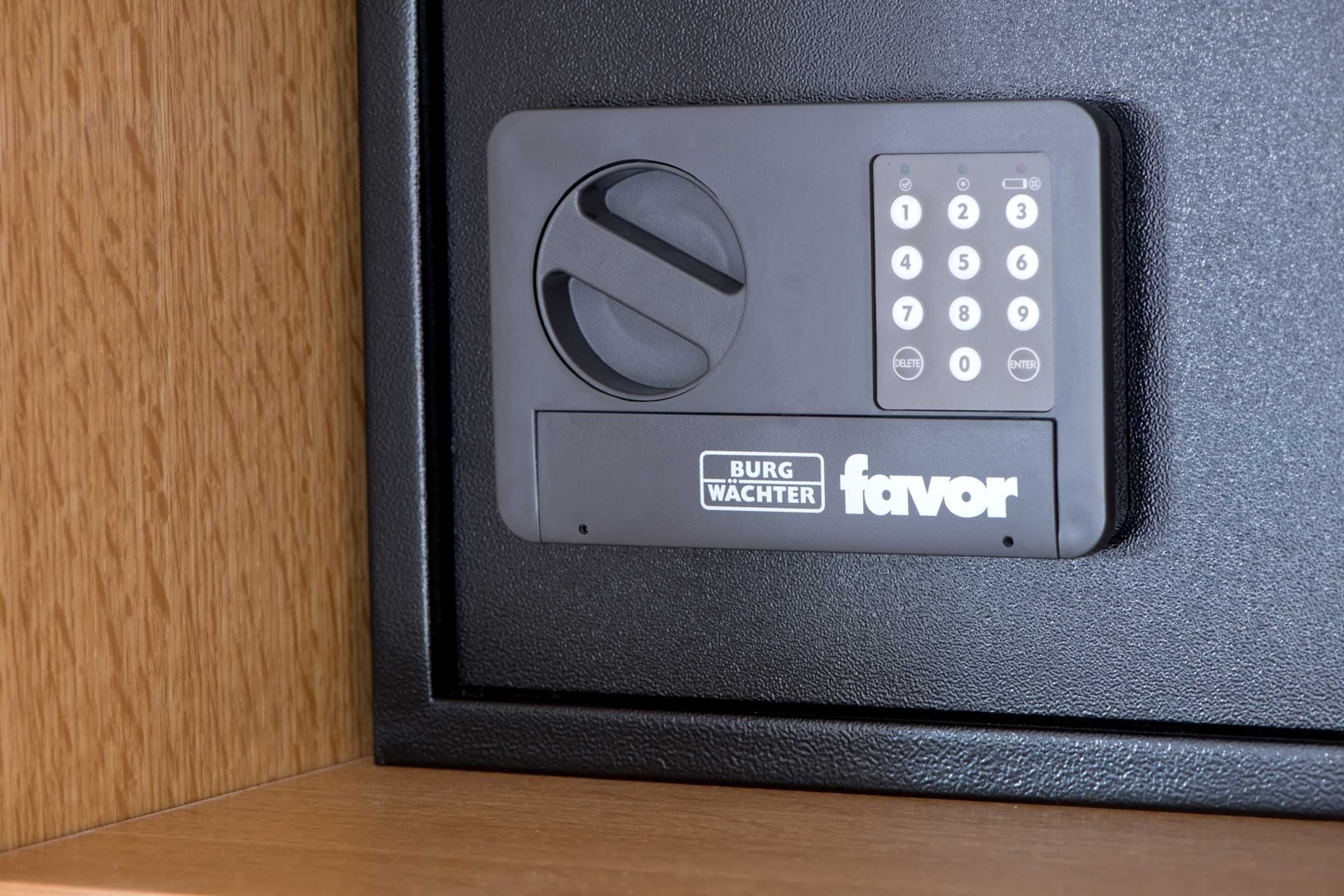 Ein schwarzes elektronisches Gerät mit Tastatur und einem Rundregler, beschriftet mit 'BURG WACHTER favor'.