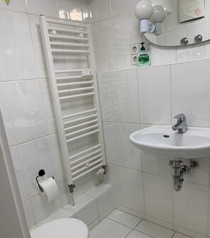 Een douche, een haardroger, handdoeken, toiletpapier