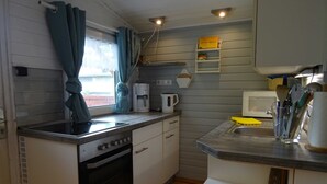 A compact kitchen with a built-in oven, a coffee maker, and a microwave. - Frehmeyer: Vacation on the farm - Ferienhaus Frehmeyer (Lindewitt)
