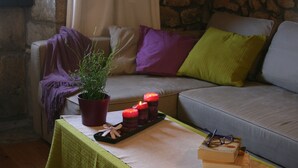 A cozy living room with a green table, a potted plant, candles, and books. - Alojamiento Rural con Encanto La Casona del Piquero (Lastres)