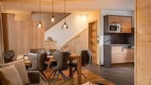 A modern kitchen with wooden cabinets and a built-in microwave. - Chalet Häuser (oetz)