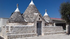 Un bâtiment en pierre doté de trois toits coniques et d’une porte centrale.