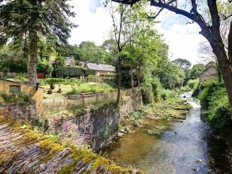 Property grounds. Charming Riverside Cottage with Authentic Decor, Private Garden, and Fishing Amenities