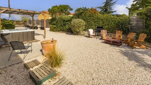 An outdoor patio area with a hot tub, seating, and a barbecue grill. - "Charming Cottage with Private Garden, Jacuzzi, and Bikes – Near Nantes & Beach" (Port-Saint-Père)