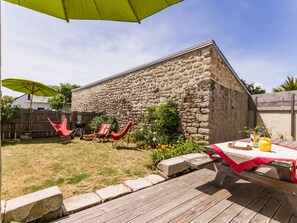 A stone building with a wooden deck and a picnic table.