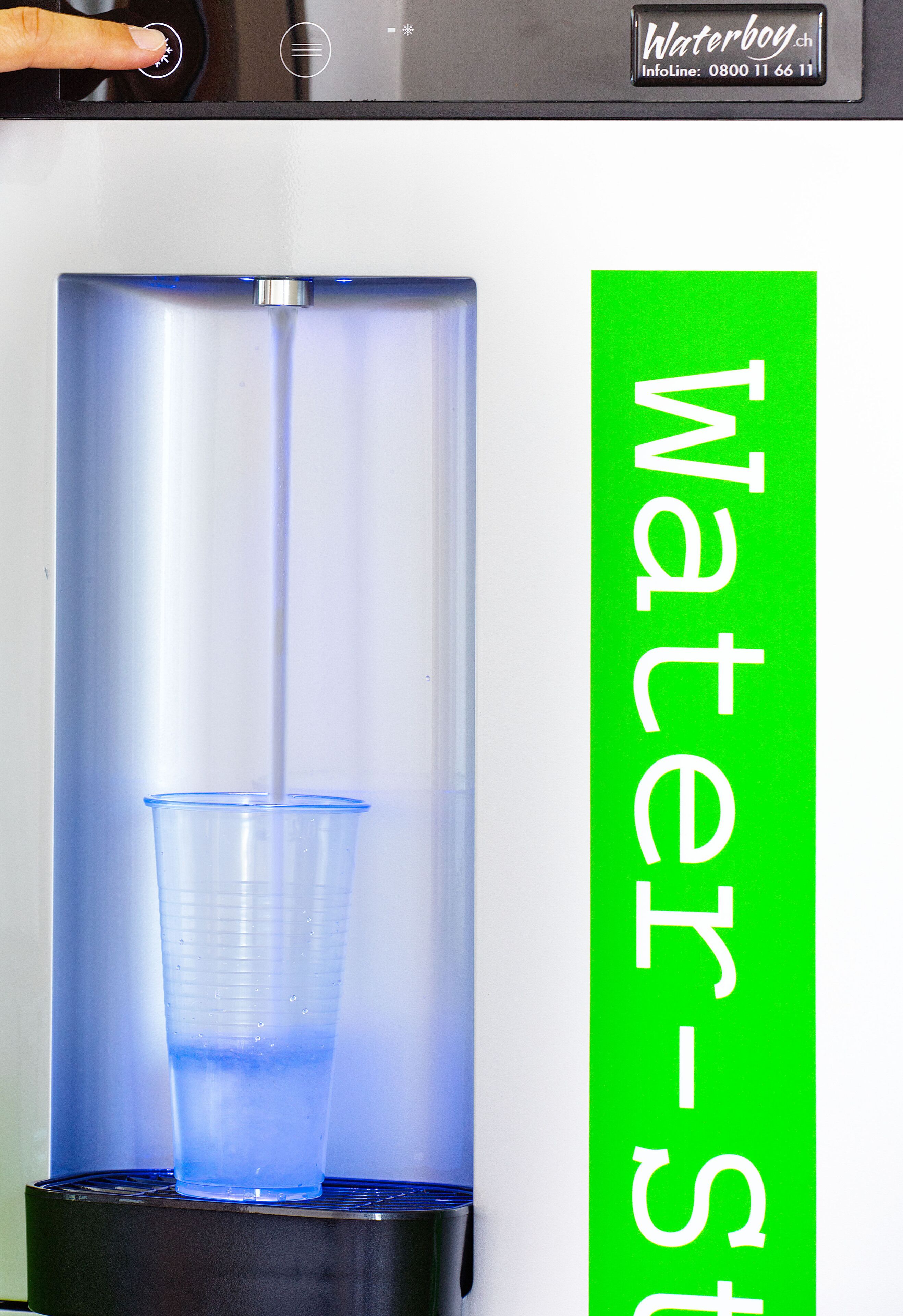 Ein Wasserspender mit einem darunter platzierten blauen Becher.