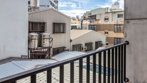 A rooftop terrace with a metal railing, a water tank, and a view of surrounding buildings. - Sleepier Multi-Minsu Tainan (Tainan)