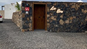 Un piccolo edificio in pietra con una porta di legno e un'insegna che riporta la scritta 'La Gua'.