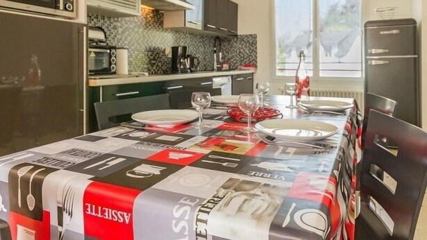 A modern kitchen with a dining area set for two. - Cozy Countryside Cottage near Brière Park with Garden, WiFi, and Modern Amenities (Missillac)
