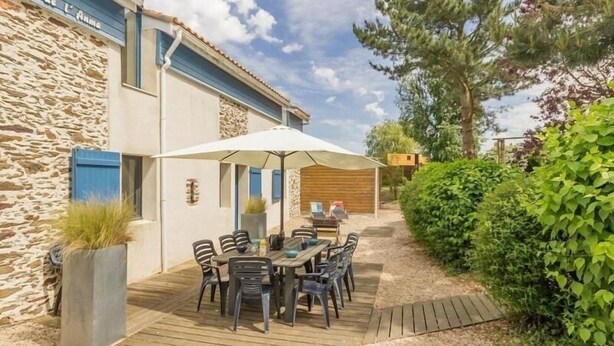 A stone building with a wooden deck and outdoor seating area.