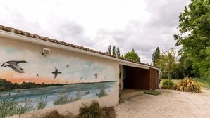 Un bâtiment orné d’une fresque représentant des oiseaux volant au-dessus d’une étendue d’eau.