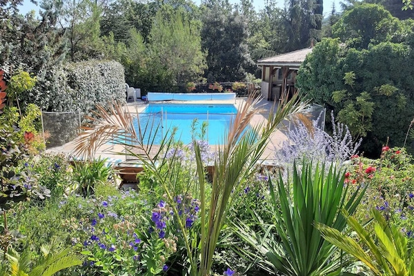 Una piscina al aire libre de temporada, sombrillas