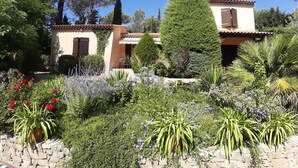 A villa with a stone wall garden, a tall tree, and a tiled roof. - Les chambres de Rocbaron (Rocbaron)