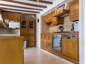 A kitchen with wooden cabinets, a stove, an oven, and a dishwasher.