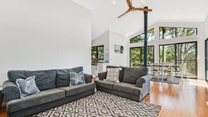 A modern living room with two grey sofas, patterned rug, and a ceiling fan. - Paws and Relax - accommodates the whole family including your fur babies (Elizabeth Beach)