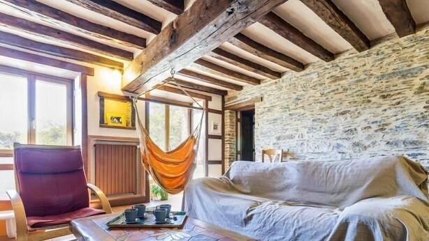 A cozy room with a wooden bench, a cushioned chair, a hammock, and a covered sofa. - Stone House Retreat with Garden & WiFi in Tranquil Countryside (Moisdon-la-Rivière)