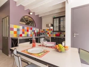 Enjoy a meal at the dining table, surrounded by modern kitchen amenities.