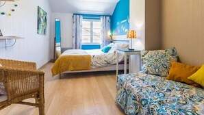 Une chambre à coucher comprenant un lit, un canapé, une chaise, un bureau et un miroir.