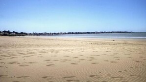 A wide sandy beach with footprints and a clear blue sky. - Luxury Seaside Gîte with Balcony, Parking, and Baby Equipment (Saint-Michel-Chef-Chef)