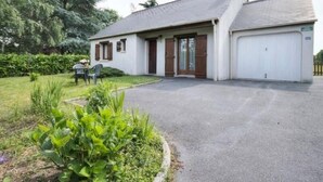 A single-story house with a garage, a front porch, and a small garden area. - Charming Cottage with Garden near Nantes & Vannes – Pet-Friendly (La Chapelle-Launay)