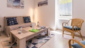 Ein modernes Wohnzimmer mit einer Couch, einem Couchtisch und einem Korbstuhl.
