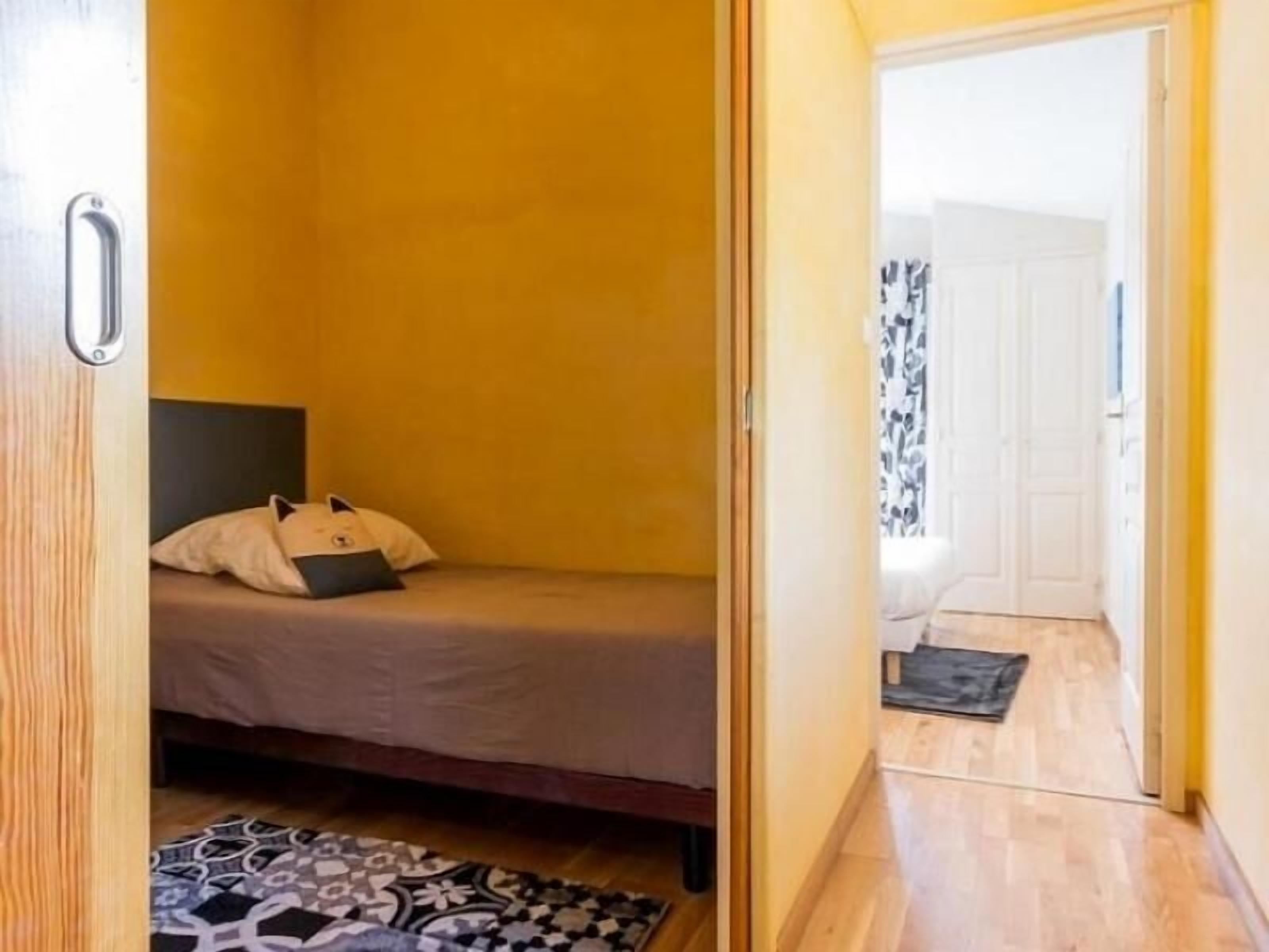 Ein gemütliches Schlafzimmer mit einem Einzelbett, einem gemusterten Teppich und Holzboden.