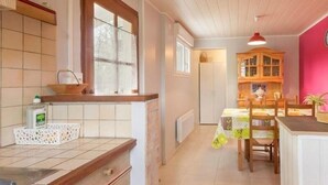 A kitchen with a window, a table with chairs, and a cabinet.