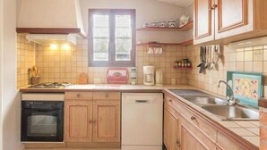 A kitchen with wooden cabinets, a dishwasher, a stove, and a window.